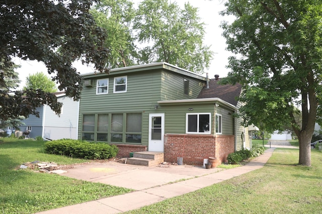 105 2nd St NE, New Prague, MN 56071 - view of front of home with brick siding, a front lawn, entry steps, and a patio