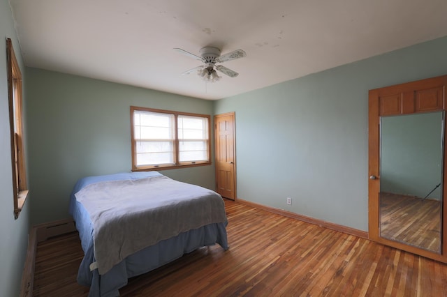 105 2nd St NE, New Prague, MN 56071 - bedroom with wood finished floors, a baseboard radiator, and ceiling fan