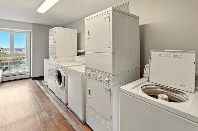 433 7th St Unit 1623, Minneapolis, MN 55415 - community laundry with estacked washer and dryer, washing machine and clothes dryer, light wood-style flooring, and baseboard heating