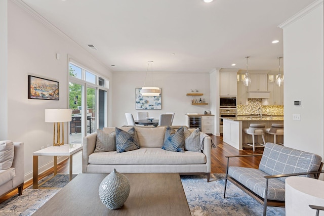 935 Lake St E Unit 211, Wayzata, MN 55391 - living area with beverage cooler, dark wood-style floors, ornamental molding, and recessed lighting