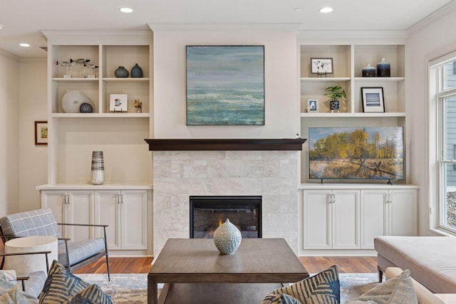 935 Lake St E Unit 211, Wayzata, MN 55391 - living room featuring light wood-type flooring, crown molding, a fireplace, built in features, and recessed lighting