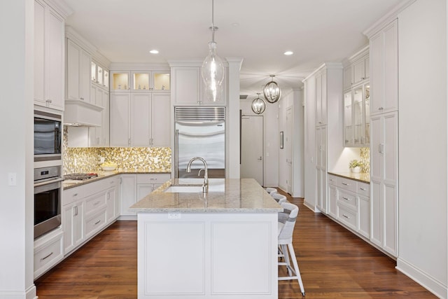 935 Lake St E Unit 211, Wayzata, MN 55391 - kitchen featuring built in appliances, decorative backsplash, white cabinetry, an island with sink, and recessed lighting