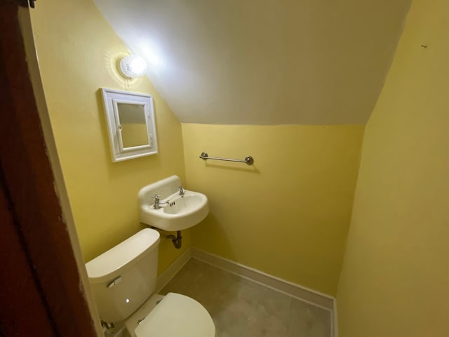 219 9th Ave SE, Rochester, MN 55904 - bathroom featuring a sink, vaulted ceiling, toilet, and baseboards