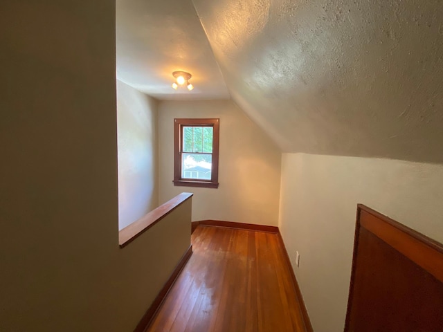 219 9th Ave SE, Rochester, MN 55904 - additional living space featuring vaulted ceiling, dark wood finished floors, a textured ceiling, and baseboards