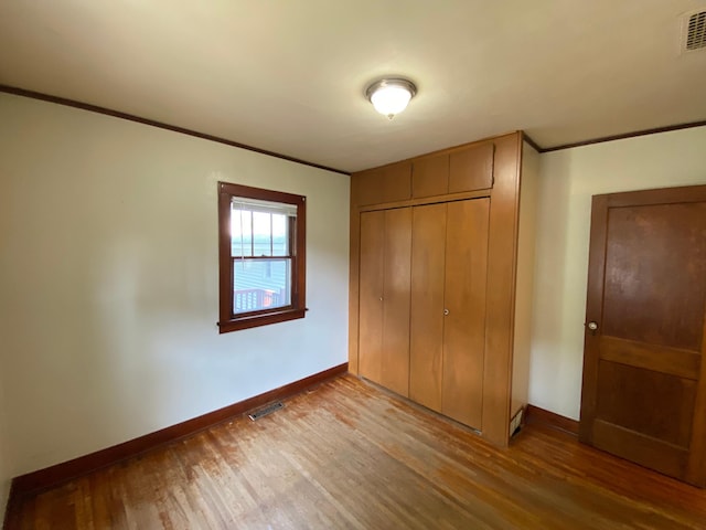 219 9th Ave SE, Rochester, MN 55904 - unfurnished bedroom featuring baseboards, wood finished floors, a closet, and ornamental molding