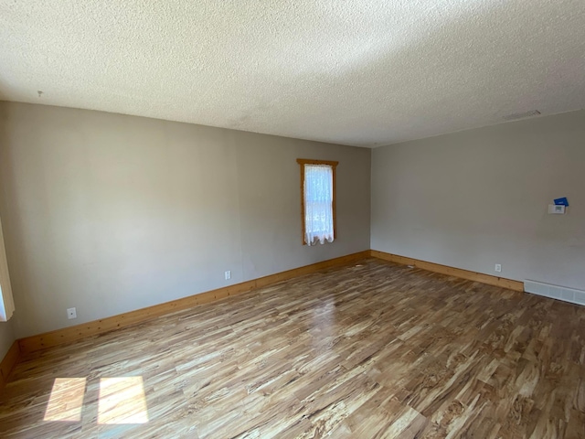 219 9th Ave SE, Rochester, MN 55904 - spare room with wood finished floors, a textured ceiling, and baseboards