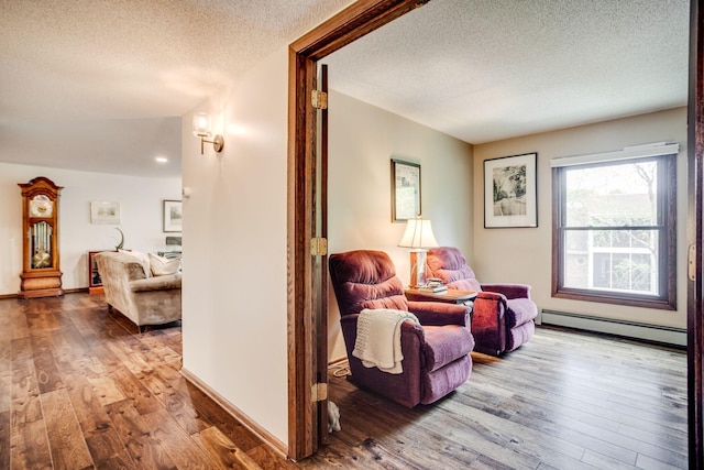 3020 Saint Albans Mill Rd Unit 309, Minnetonka, MN 55305 - sitting room featuring a baseboard heating unit, a textured ceiling, and hardwood / wood-style floors