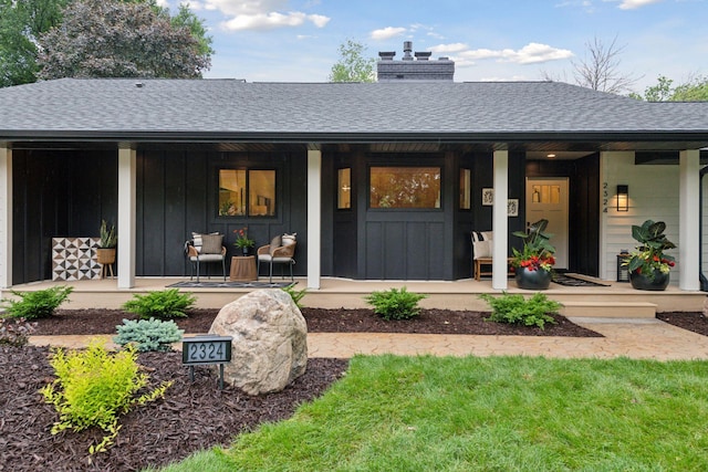 2324 Rivendell Ln, Minnetonka, MN 55305 - property entrance with covered porch, roof with shingles, board and batten siding, and a chimney
