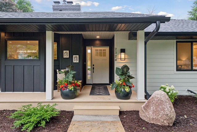2324 Rivendell Ln, Minnetonka, MN 55305 - entrance to property with covered porch, roof with shingles, a chimney, and board and batten siding