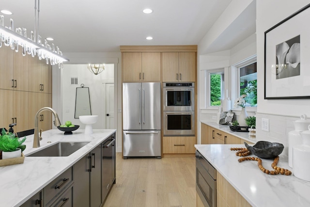 2324 Rivendell Ln, Minnetonka, MN 55305 - kitchen with stainless steel appliances, light brown cabinetry, light stone countertops, light wood finished floors, and recessed lighting