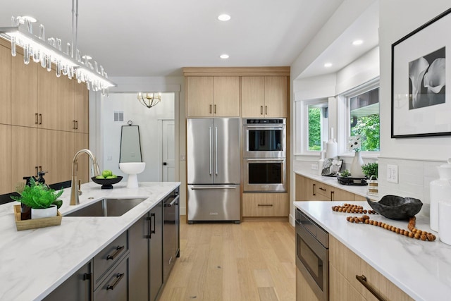 2324 Rivendell Ln, Minnetonka, MN 55305 - kitchen featuring appliances with stainless steel finishes, light brown cabinetry, light wood-style flooring, light stone countertops, and recessed lighting
