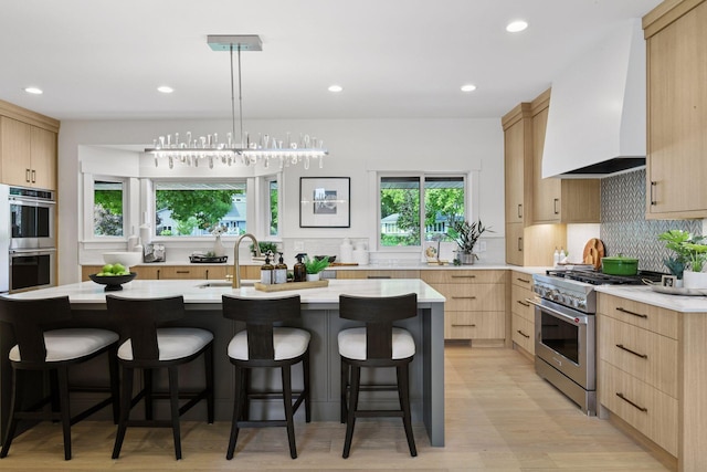 2324 Rivendell Ln, Minnetonka, MN 55305 - kitchen featuring appliances with stainless steel finishes, light brown cabinetry, light countertops, custom range hood, and a breakfast bar area