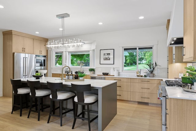 2324 Rivendell Ln, Minnetonka, MN 55305 - kitchen with light brown cabinetry, premium appliances, light wood finished floors, backsplash, and recessed lighting