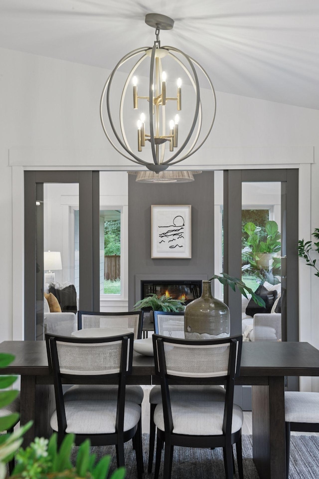 2324 Rivendell Ln, Minnetonka, MN 55305 - dining space featuring healthy amount of natural light, a chandelier, and a glass covered fireplace