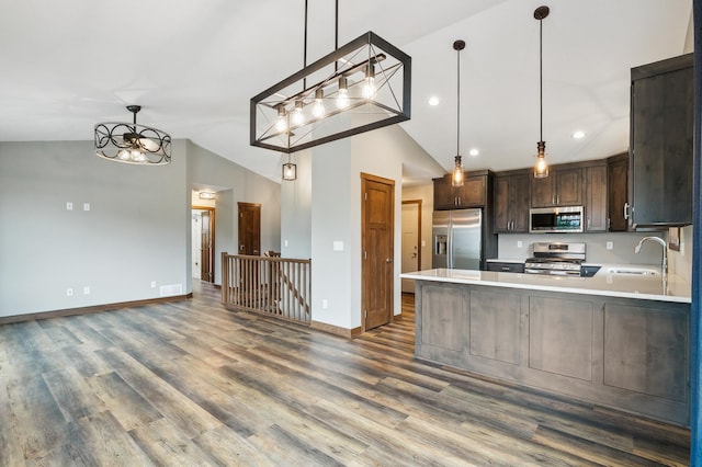26884 709th St, Lake City, MN 55041 - kitchen featuring stainless steel appliances, vaulted ceiling, light countertops, dark brown cabinets, and dark wood finished floors