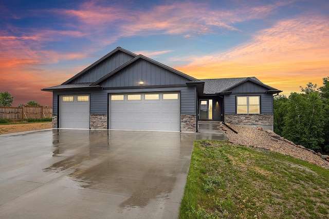 26884 709th St, Lake City, MN 55041 - view of front facade featuring a garage, concrete driveway, stone siding, and board and batten siding