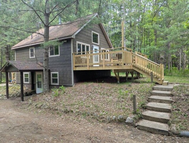 24863 Norway Pine Pl, Ross Lake Twp, MN 56447 - view of home's exterior featuring stairway, a wooden deck, roof with shingles, and a wooded view