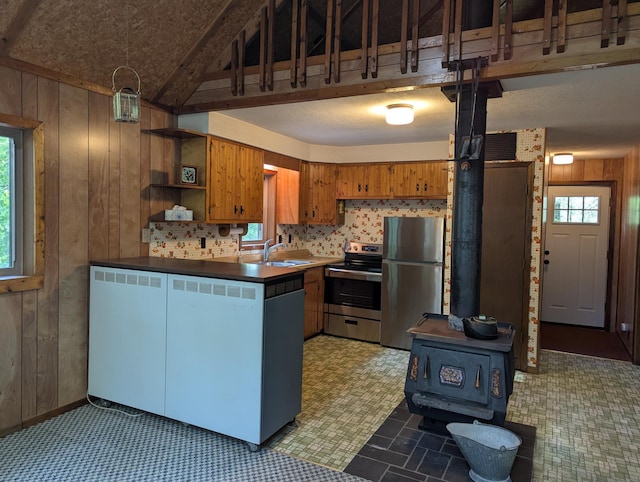 24863 Norway Pine Pl, Ross Lake Twp, MN 56447 - kitchen with stainless steel appliances, wooden walls, a sink, a peninsula, and a wood stove