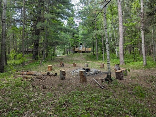 24863 Norway Pine Pl, Ross Lake Twp, MN 56447 - view of yard with a forest view, a wooden deck, and an outdoor fire pit