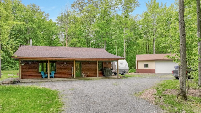 W8567 County Road Mm, Mead Twp, WI 54437 - view of front of property with an outbuilding, a shingled roof, faux log siding, driveway, and covered porch