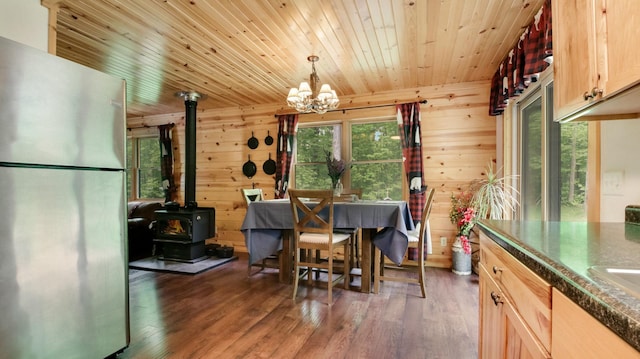 W8567 County Road Mm, Mead Twp, WI 54437 - dining area featuring wooden ceiling, a wood stove, a chandelier, wood finished floors, and wooden walls
