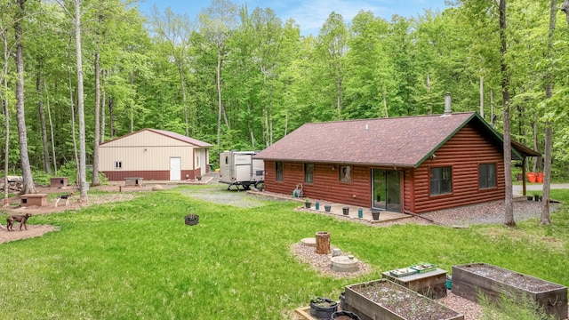 W8567 County Road Mm, Mead Twp, WI 54437 - back of property with a vegetable garden, a lawn, a shingled roof, a view of trees, and a patio