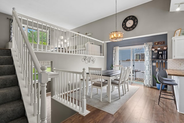903 6th Ave NW, Buffalo, MN 55313 - dining space featuring hardwood / wood-style flooring, a chandelier, high vaulted ceiling, and stairs