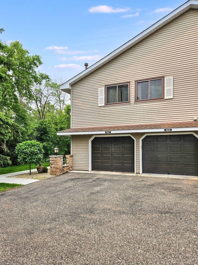 7635 Wedgewood Ct N, Maple Grove, MN 55311 - view of side of property with asphalt driveway and a garage