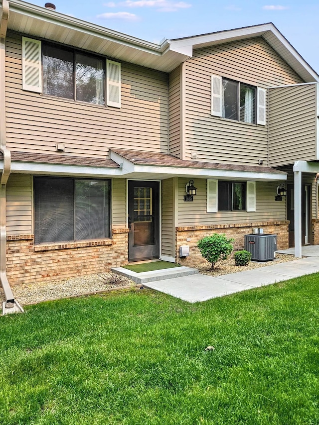 7635 Wedgewood Ct N, Maple Grove, MN 55311 - view of front of home with brick siding, central air condition unit, and a front lawn