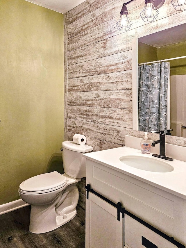 7635 Wedgewood Ct N, Maple Grove, MN 55311 - bathroom featuring wood walls, toilet, vanity, wood finished floors, and baseboards