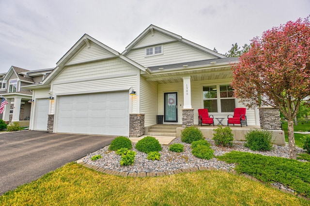 1345 Bluff Border Rd, New Richmond, WI 54017 - craftsman-style home featuring a porch, an attached garage, asphalt driveway, and stone siding