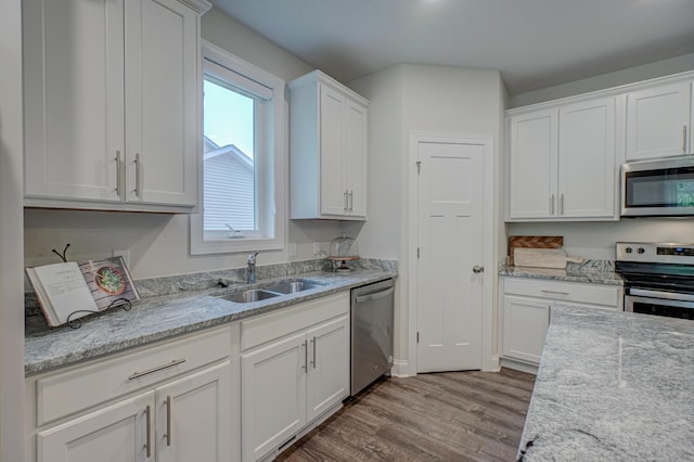 1345 Bluff Border Rd, New Richmond, WI 54017 - kitchen with stainless steel appliances, a sink, wood finished floors, white cabinetry, and light stone countertops