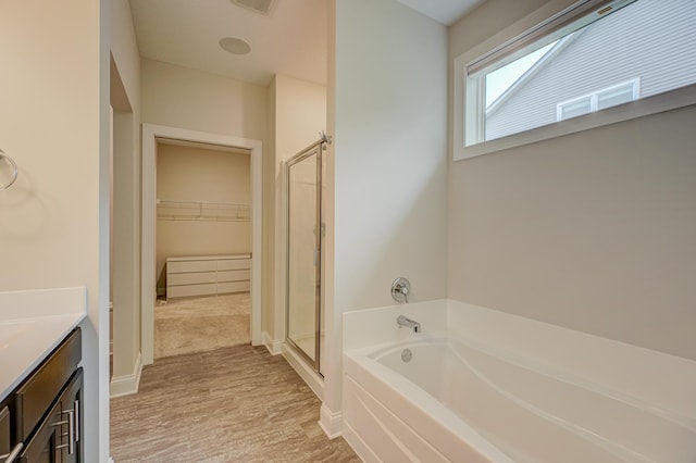 1345 Bluff Border Rd, New Richmond, WI 54017 - full bath featuring a bath, a stall shower, vanity, a spacious closet, and wood finished floors