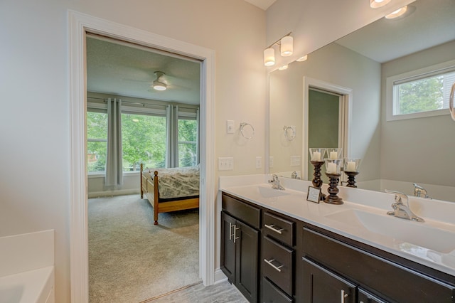 1345 Bluff Border Rd, New Richmond, WI 54017 - ensuite bathroom with double vanity, a ceiling fan, a tub to relax in, and baseboards
