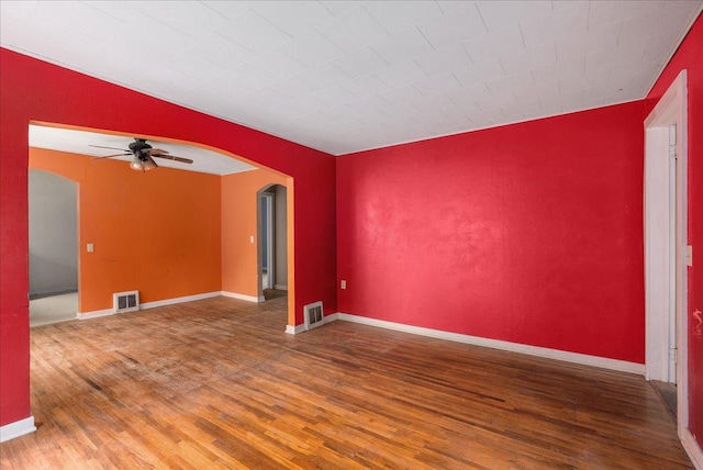 543 Pearl St, River Falls, WI 54022 - unfurnished room featuring arched walkways, wood finished floors, a ceiling fan, and baseboards
