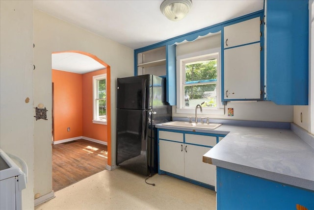 543 Pearl St, River Falls, WI 54022 - kitchen featuring freestanding refrigerator, a sink, arched walkways, and light countertops