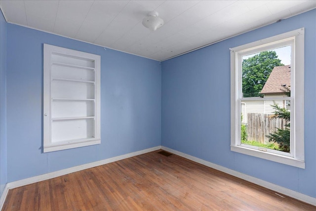 543 Pearl St, River Falls, WI 54022 - empty room featuring built in features, wood finished floors, and baseboards