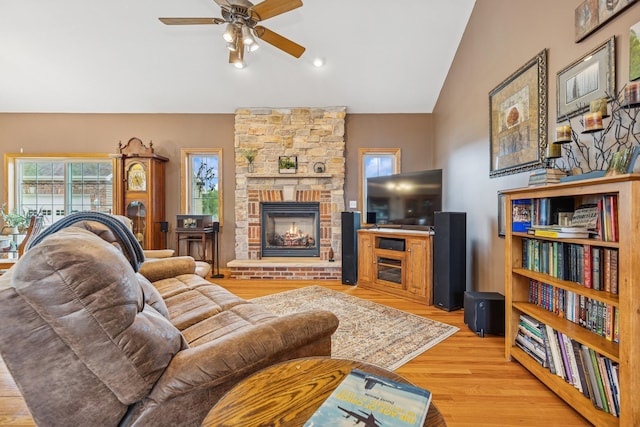 26033 607th St, Mantorville, MN 55955 - living area featuring lofted ceiling, ceiling fan, light wood-type flooring, and a stone fireplace