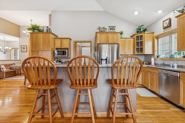 26033 607th St, Mantorville, MN 55955 - kitchen with appliances with stainless steel finishes, a chandelier, lofted ceiling, glass insert cabinets, and a breakfast bar area