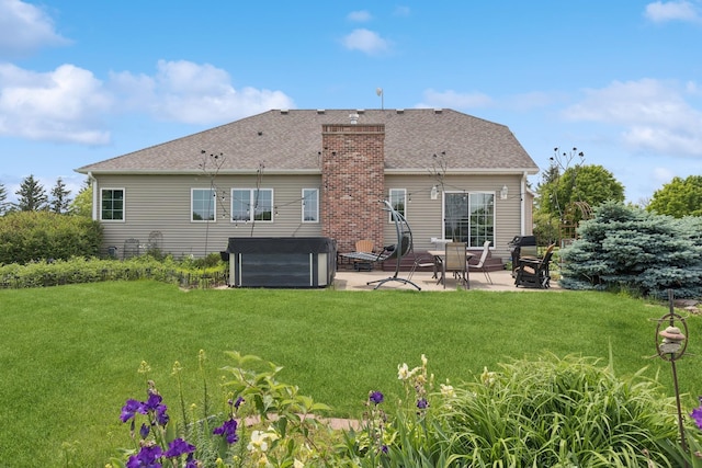 26033 607th St, Mantorville, MN 55955 - back of house featuring a patio, a hot tub, a lawn, and a chimney