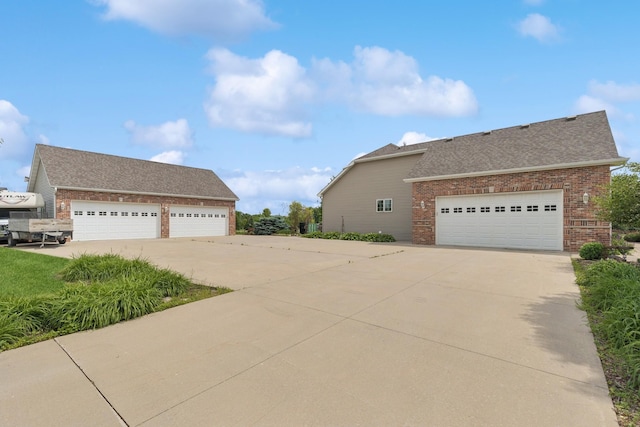 26033 607th St, Mantorville, MN 55955 - view of side of home featuring brick siding, a shingled roof, and a garage