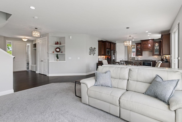 3751 Crane Island Ct, Minnetrista, MN 55331 - living room with baseboards, recessed lighting, dark wood-type flooring, dark carpet, and a chandelier