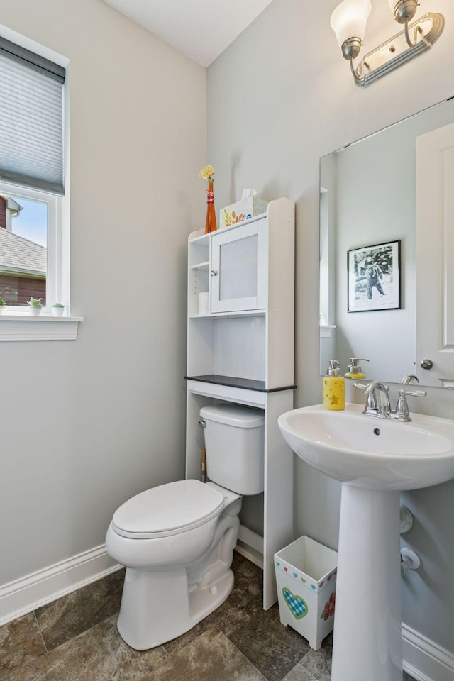 3751 Crane Island Ct, Minnetrista, MN 55331 - bathroom featuring toilet, baseboards, a sink, and stone finish flooring