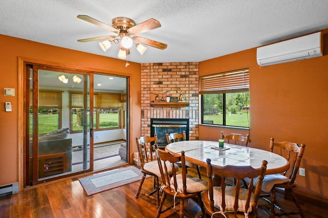 3865 Wahtomin Trl NW, Alexandria, MN 56308 - dining area featuring an AC wall unit, wood finished floors, a textured ceiling, a brick fireplace, and a baseboard heating unit