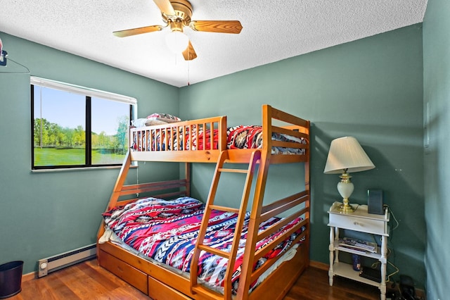 3865 Wahtomin Trl NW, Alexandria, MN 56308 - bedroom with a baseboard heating unit, a textured ceiling, wood finished floors, baseboards, and a ceiling fan