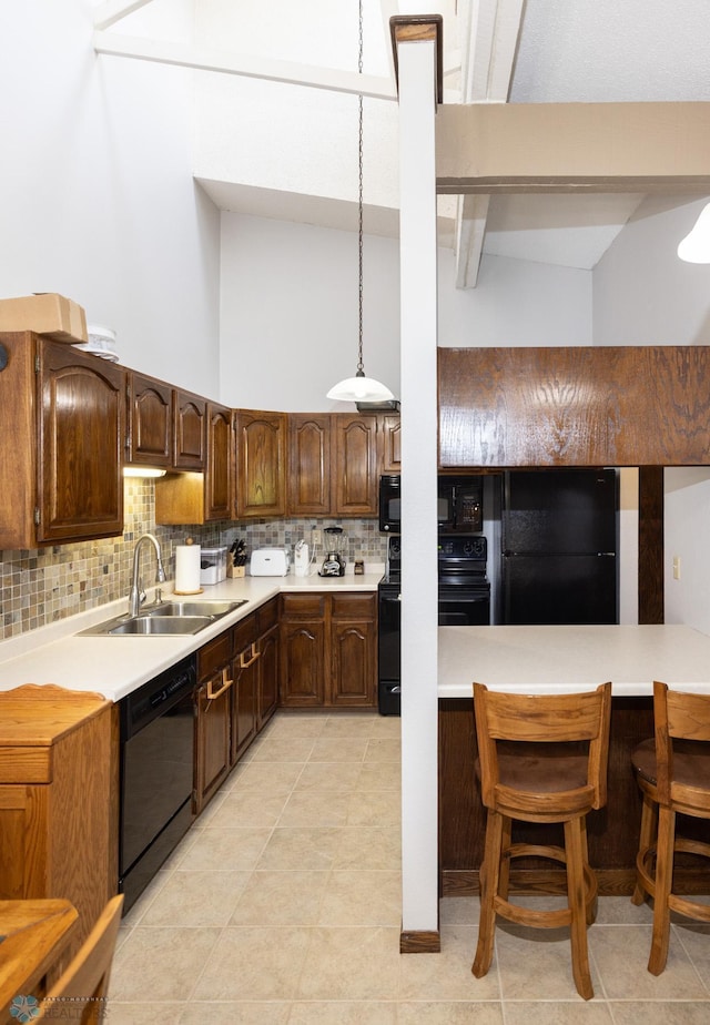1427 23rd St S, Fargo, ND 58103 - kitchen with black appliances, a sink, backsplash, light countertops, and a towering ceiling