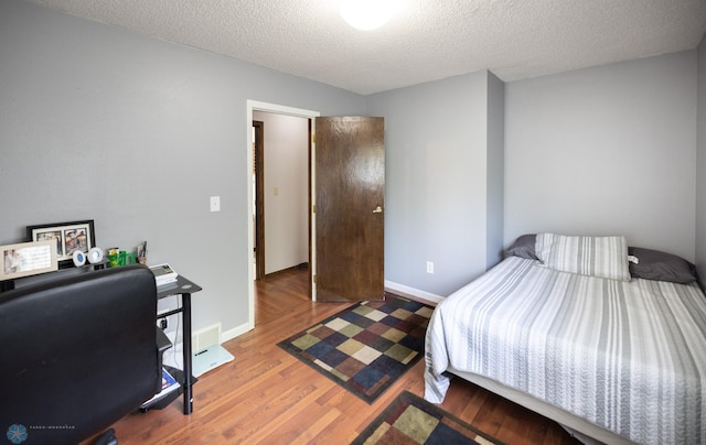 1427 23rd St S, Fargo, ND 58103 - bedroom with wood finished floors, a textured ceiling, and baseboards