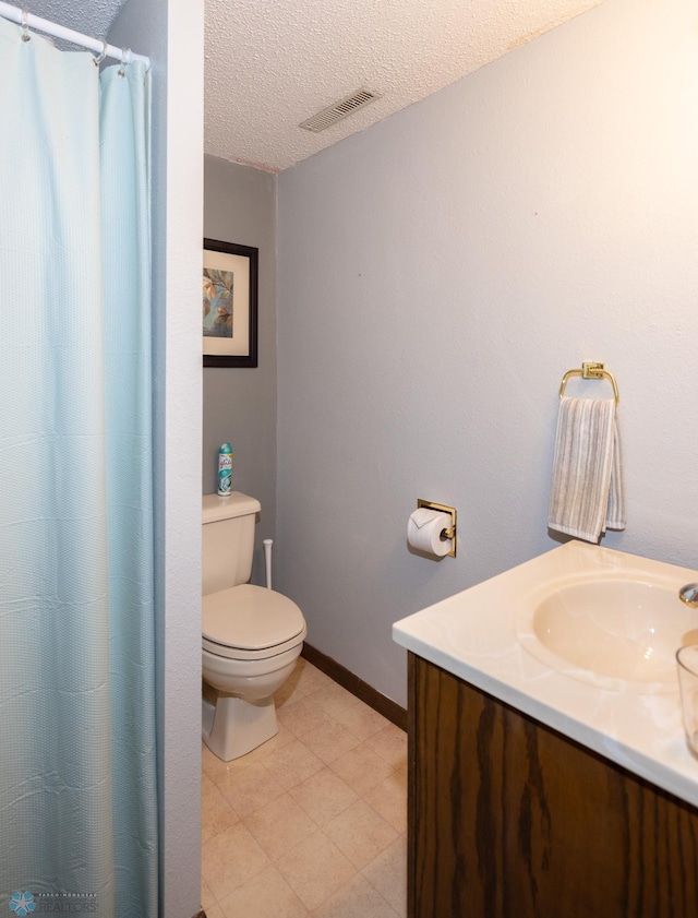 1427 23rd St S, Fargo, ND 58103 - full bathroom featuring vanity, toilet, a textured ceiling, a shower with curtain, and baseboards