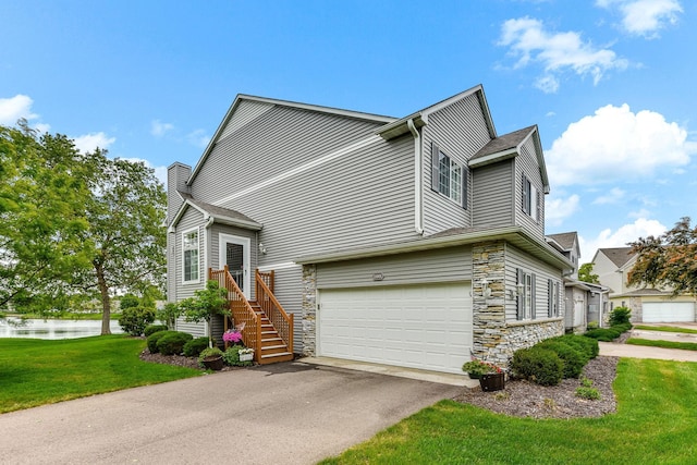 11001 Isanti Ct NE, Blaine, MN 55449 - view of side of home featuring stone siding, asphalt driveway, an attached garage, and a water view