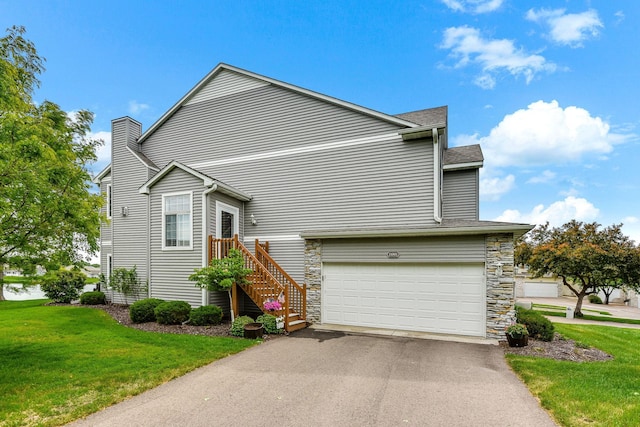11001 Isanti Ct NE, Blaine, MN 55449 - view of side of home with an attached garage, a lawn, driveway, stone siding, and roof with shingles
